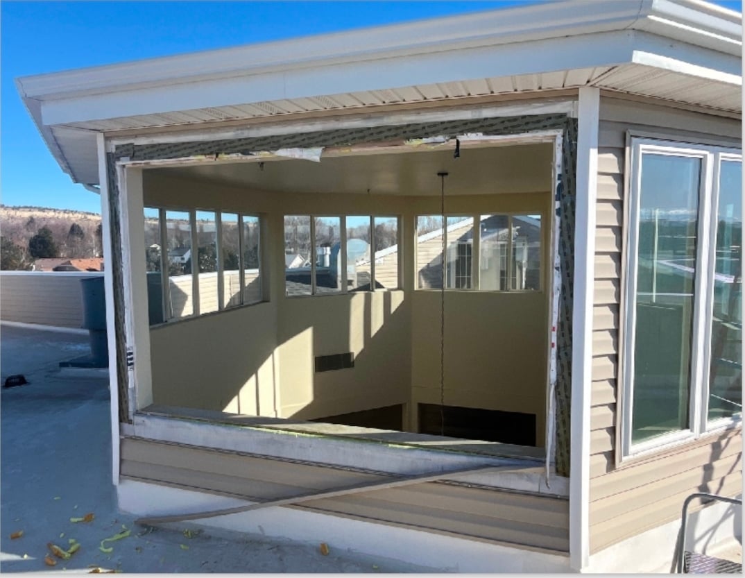 Outdoor patio with retractable screen door system open, showing clear view to landscaped surroundings with mountains in distance